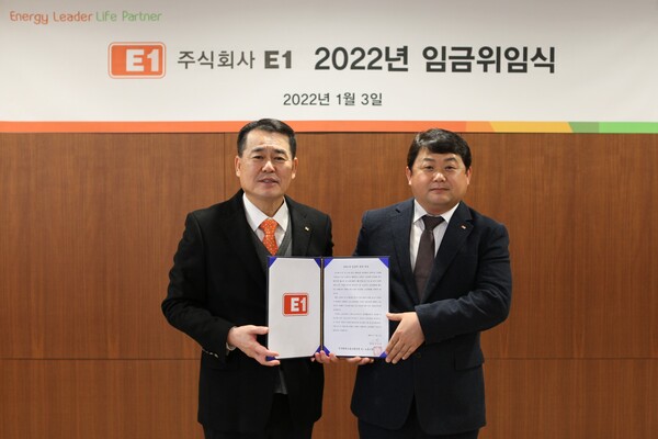 E1 구자용 회장(왼쪽)과 박승규 노조위원장이 2022년도 임금에 관한 위임장을 들고 기념 촬영을 하고 있다.
