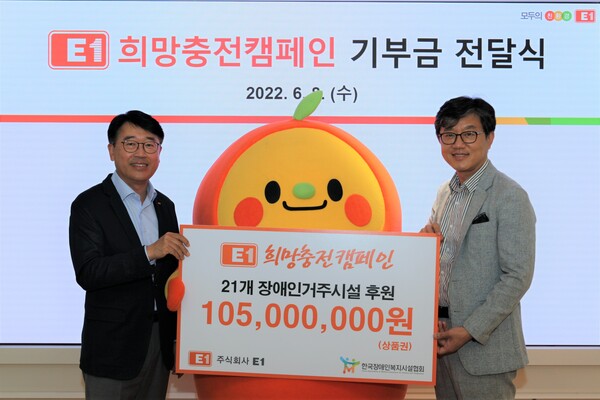 E1 전진만 대외협력실장(왼쪽)이 한국장애인복지시설협회 정석왕 회장에게 희망충전캠페인 기부금 1억 500만원을 전달하고 있다.